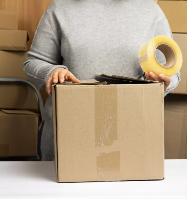 Woman taping a cardbord box